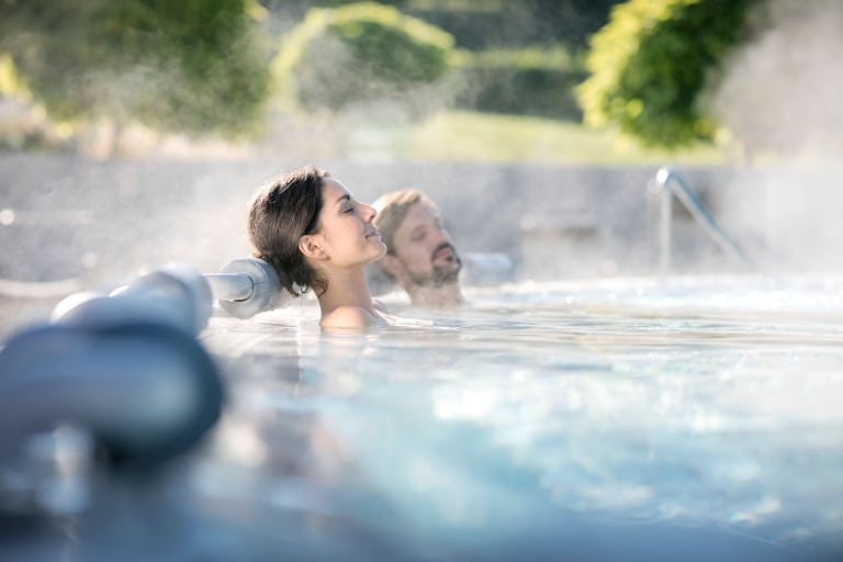 Frau genießt dampfendes Thermalwasser